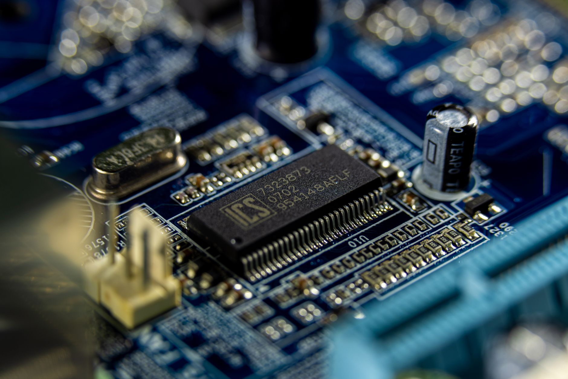 Detailed shot of a microprocessor on a blue motherboard showcasing electronic components.