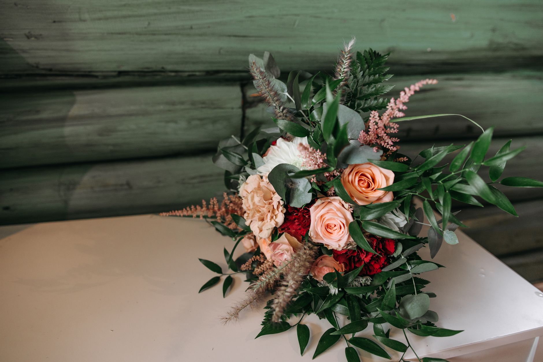 A stylish bouquet featuring roses and greenery on a rustic background. Perfect for weddings or celebrations.
