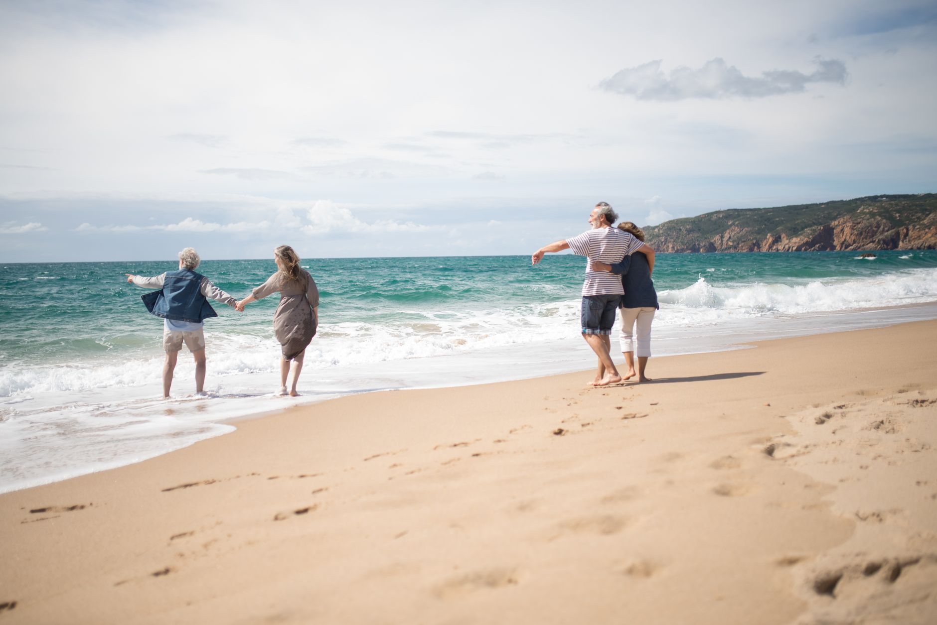 Seniors enjoying a relaxing walk on a beautiful beach in Portugal's scenic coastline.