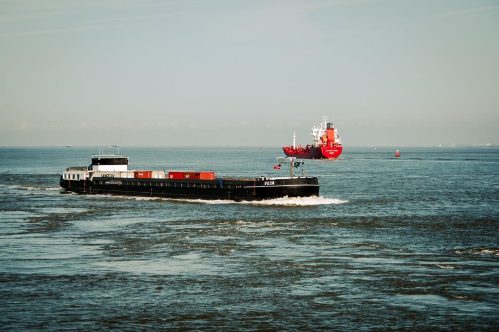 Container ships navigating ocean waters under a clear sky, showcasing maritime transport.