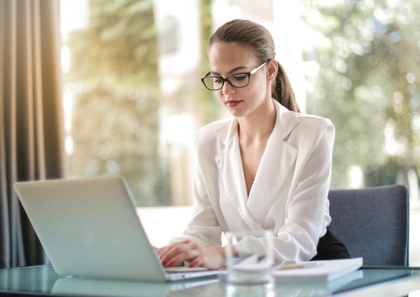 Confident businesswoman using a laptop at her desk, focused on her work.